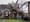 A large tree lays on top of a house in the aftermath of a hurricane.